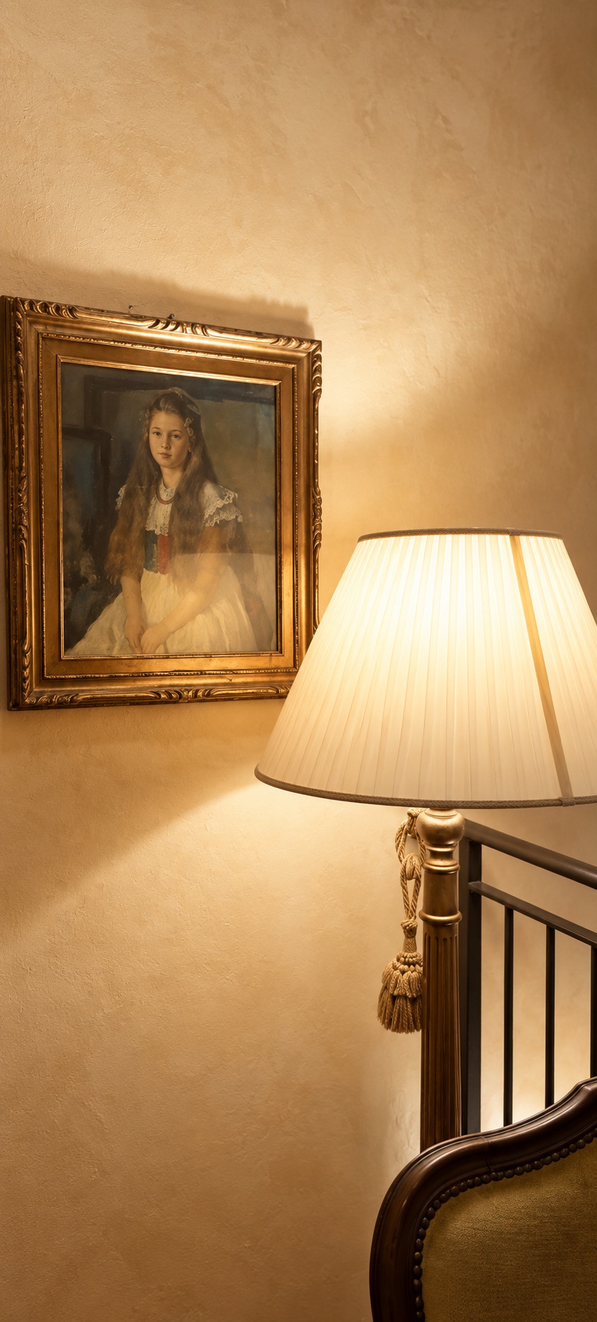 Ritratto d'epoca in cornice dorata illuminato da una lampada negli interni di Villa Sant'Erasmo
