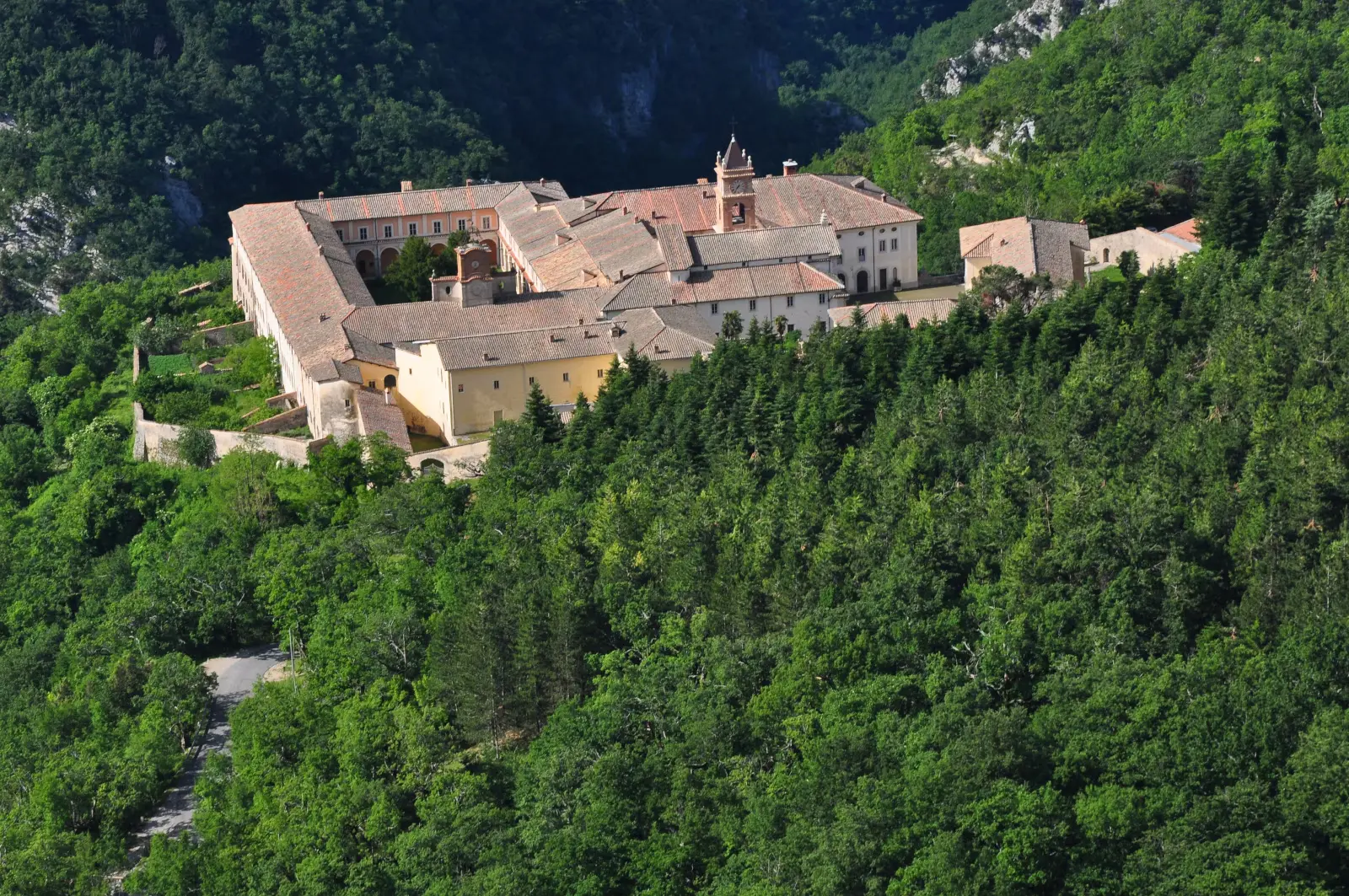 Veduta aerea della Certosa di Trisulti immersa nei boschi dei Monti Ernici, con il campanile e i tetti in terracotta