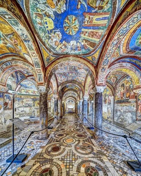 L'interno della Cripta di San Magno ad Anagni con volte affrescate, colonne in pietra e pavimento cosmatesco