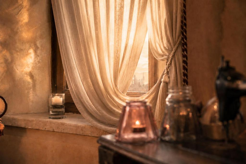 Finestra velata e candele accese negli interni di Villa Sant'Erasmo