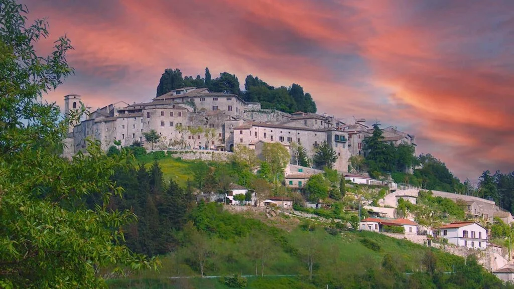 Il borgo di Fumone arroccato sul colle al tramonto, con il cielo rosato sopra le case in pietra